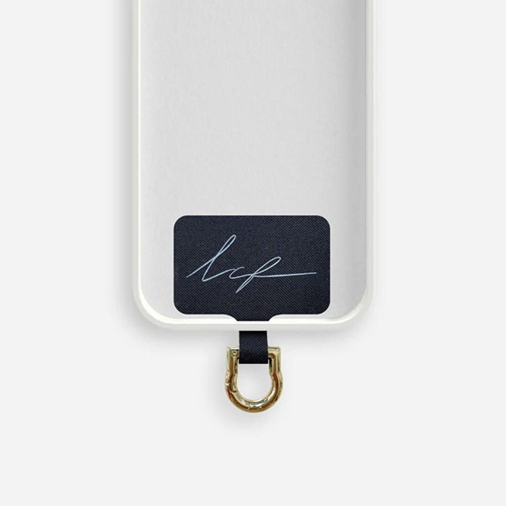 Phone case with an adapter for phone strap made of a black tag and a gold carabiner on a white background