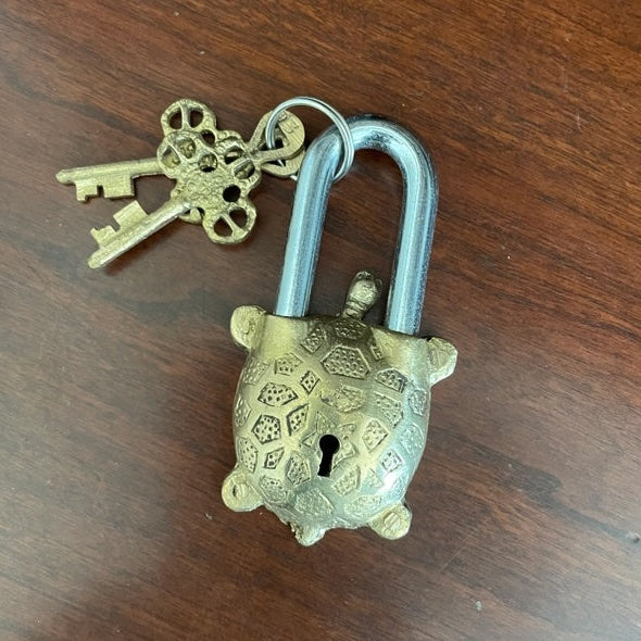 Bronze padlock with a key on a wooden surface
