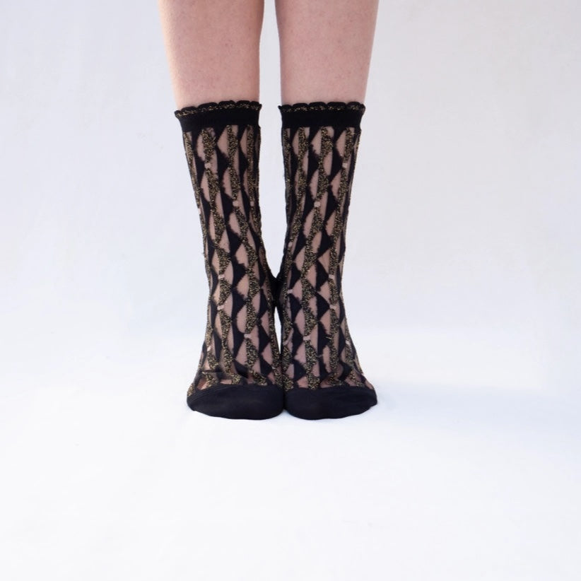 Black lace socks worn by a person on a white background