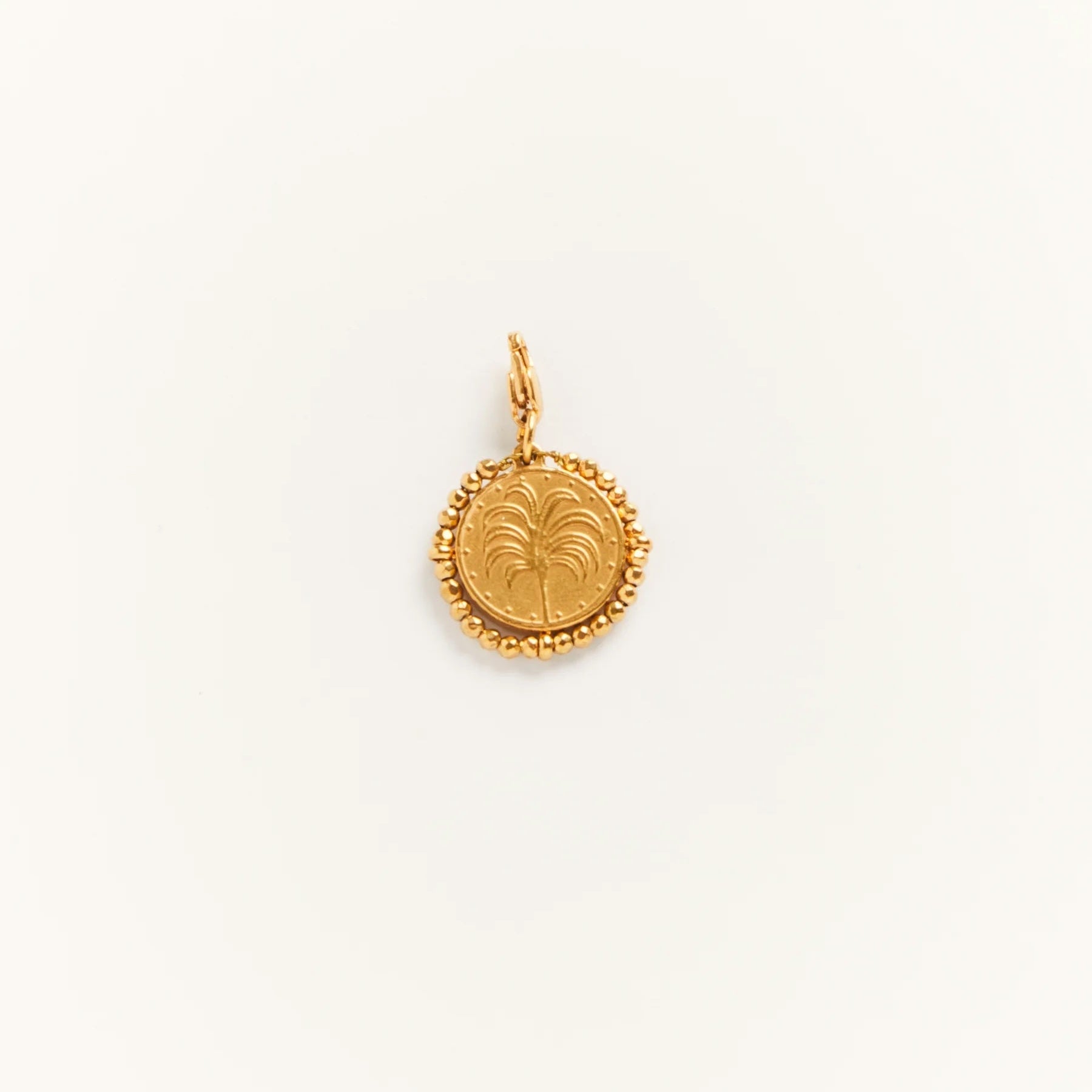 Gold pendant with a decorative design on a white background