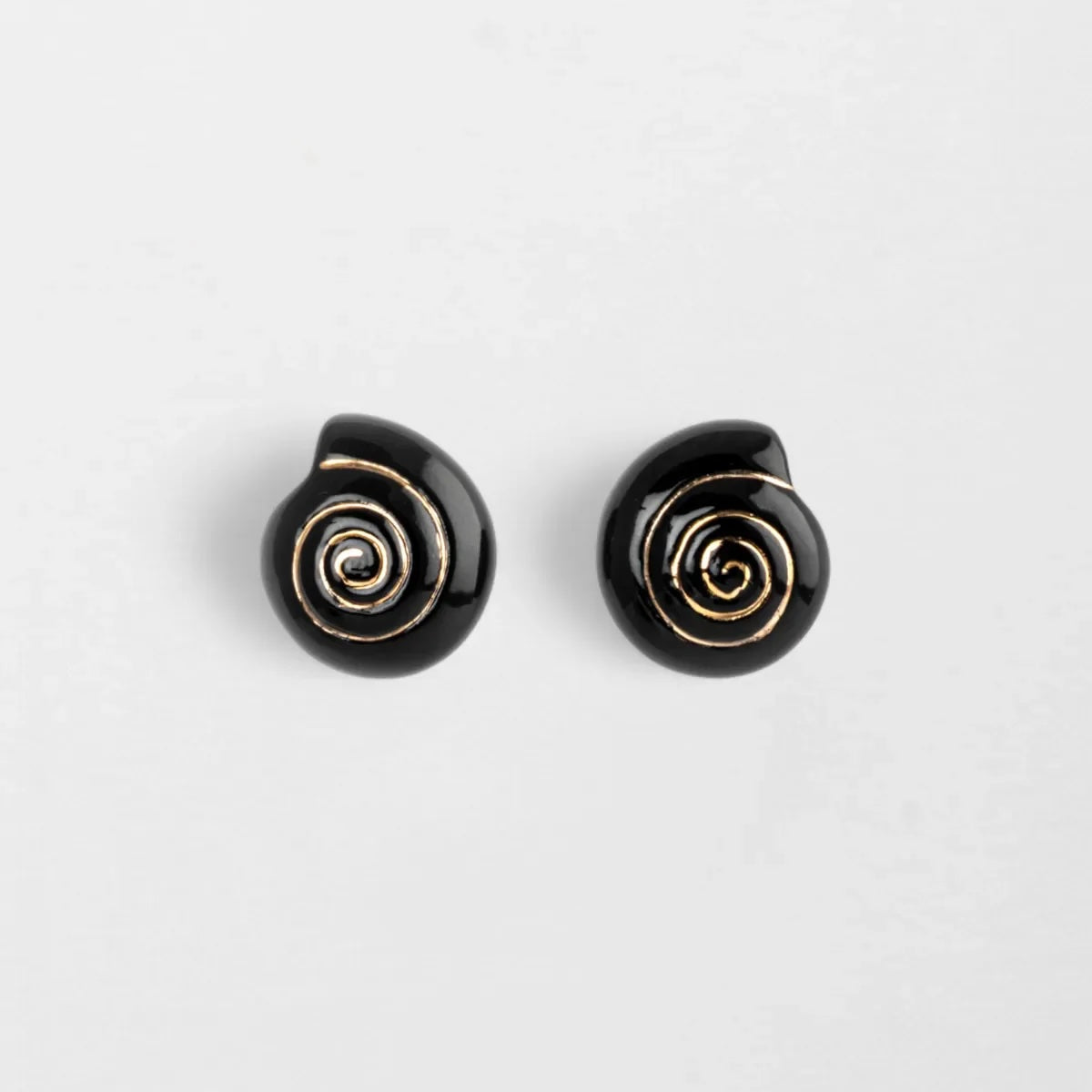 Black spiral earrings on a light gray background