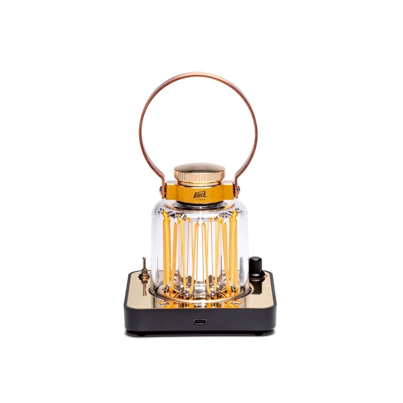 Lantern with clear glass jar and brass accents on a white background