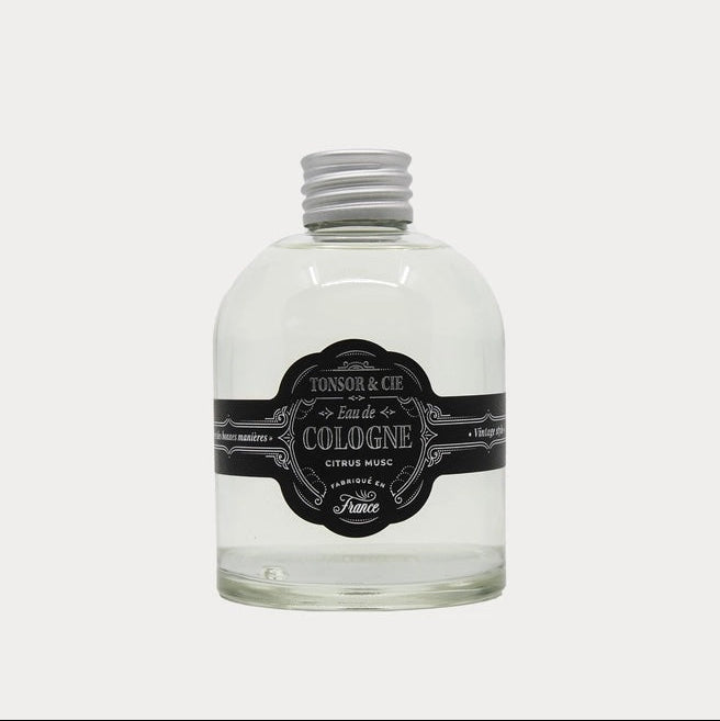 Clear cologne bottle with a black label on a white background
