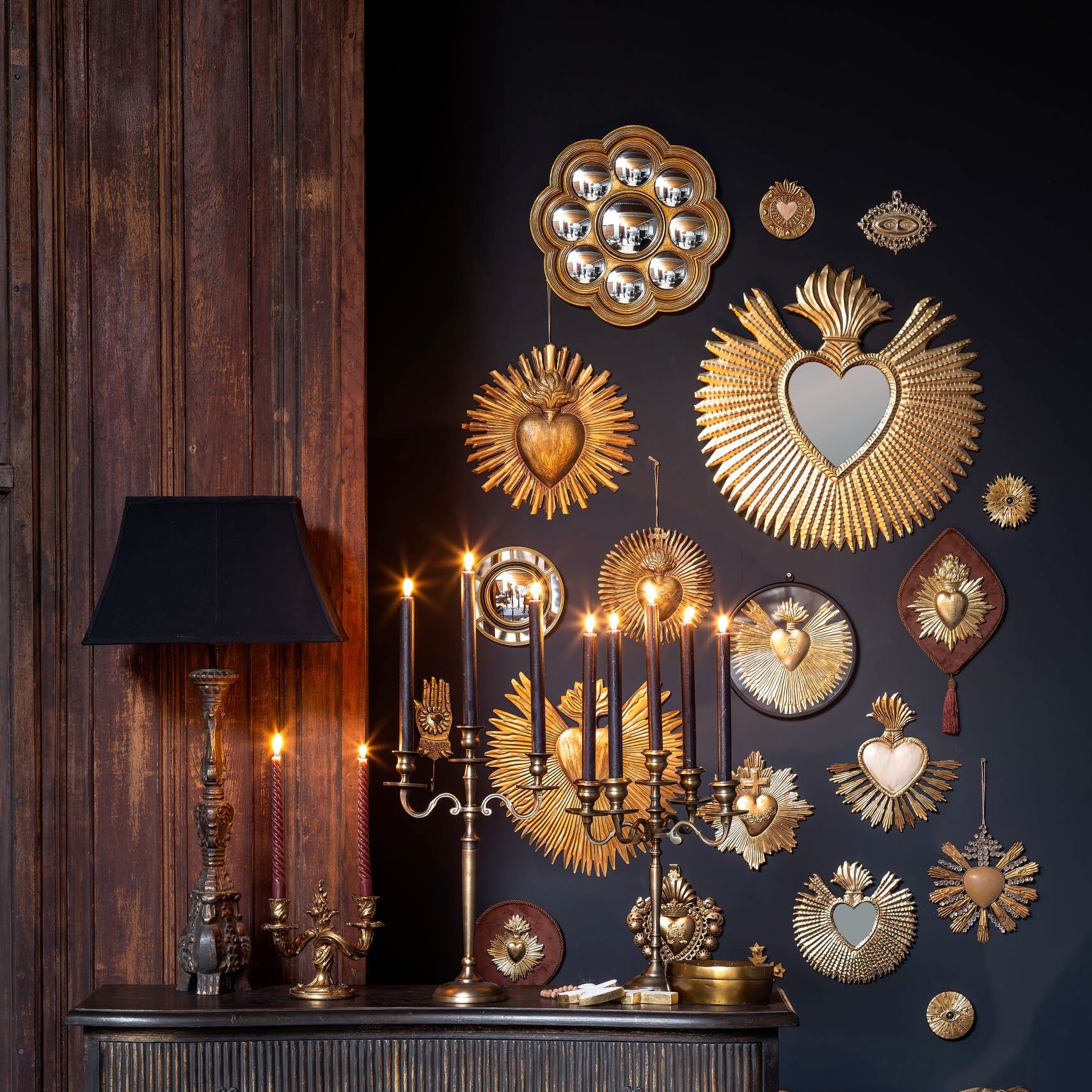 Decorative wall with gold wall art and a dark wooden dresser.