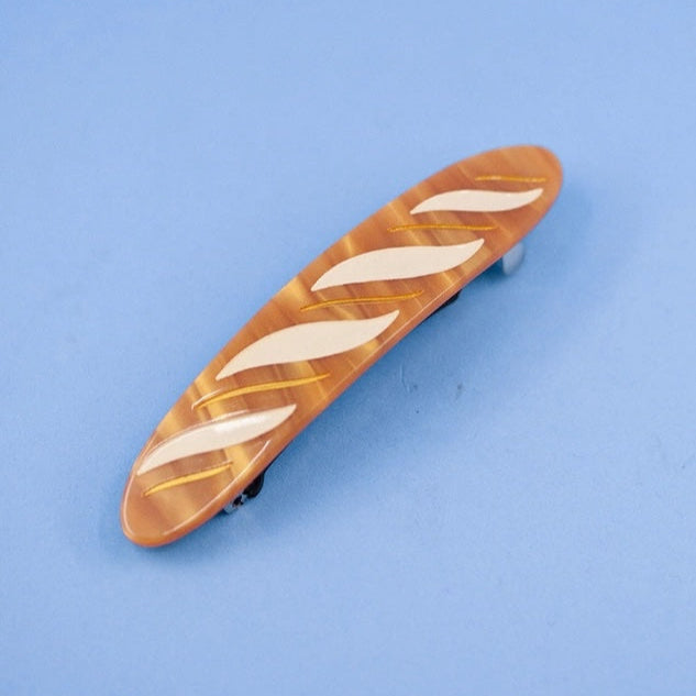 Wooden bread-shaped object with white markings on a blue background