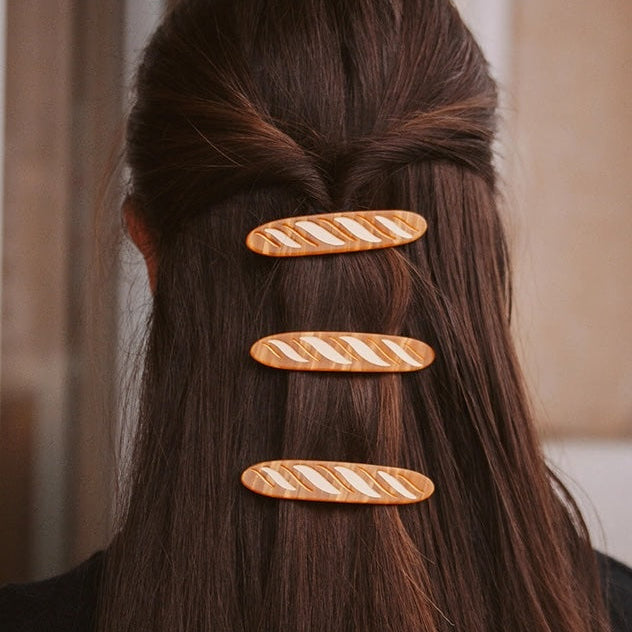 Three decorative hair clips on a person's hair with a blurred background