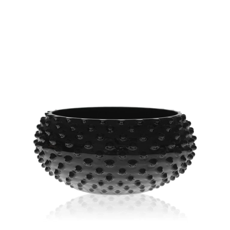Decorative black glass bowl with a textured surface on a white background