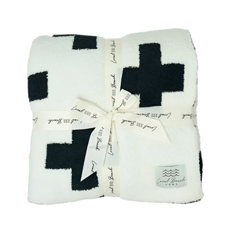 White blanket with black crosses and a bow, featuring 'Local Beach' branding.