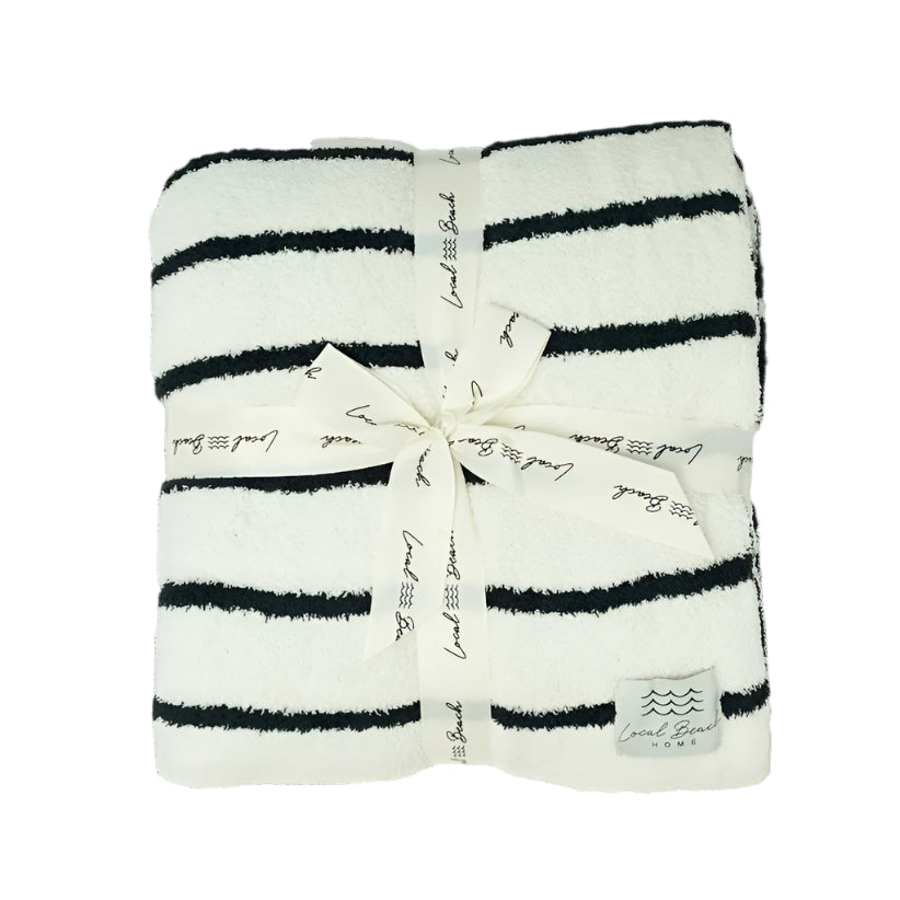 Striped towel with a bow and branding on a black background