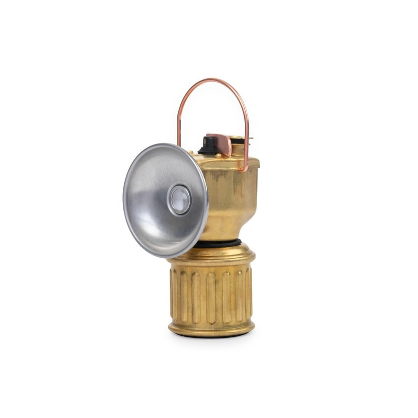 Brass camping lantern with a silver reflector on a white background