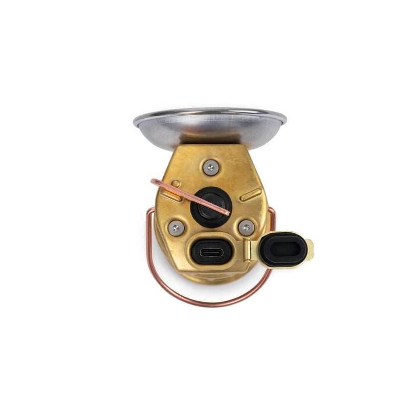 Brass-colored mechanical device with a light shade on a white background