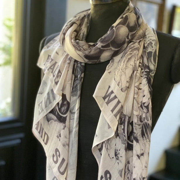 Mannequin wearing a scarf with vintage-style text and graphics