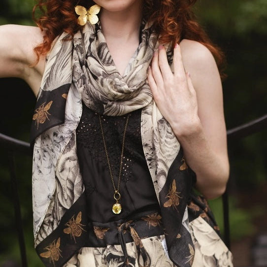 Woman wearing a patterned scarf and dress with a blurred background