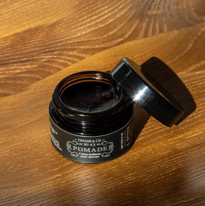Open jar of pomade on a wooden surface