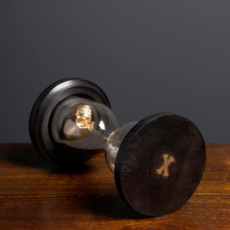 gold skull sandtimer on a wooden surface