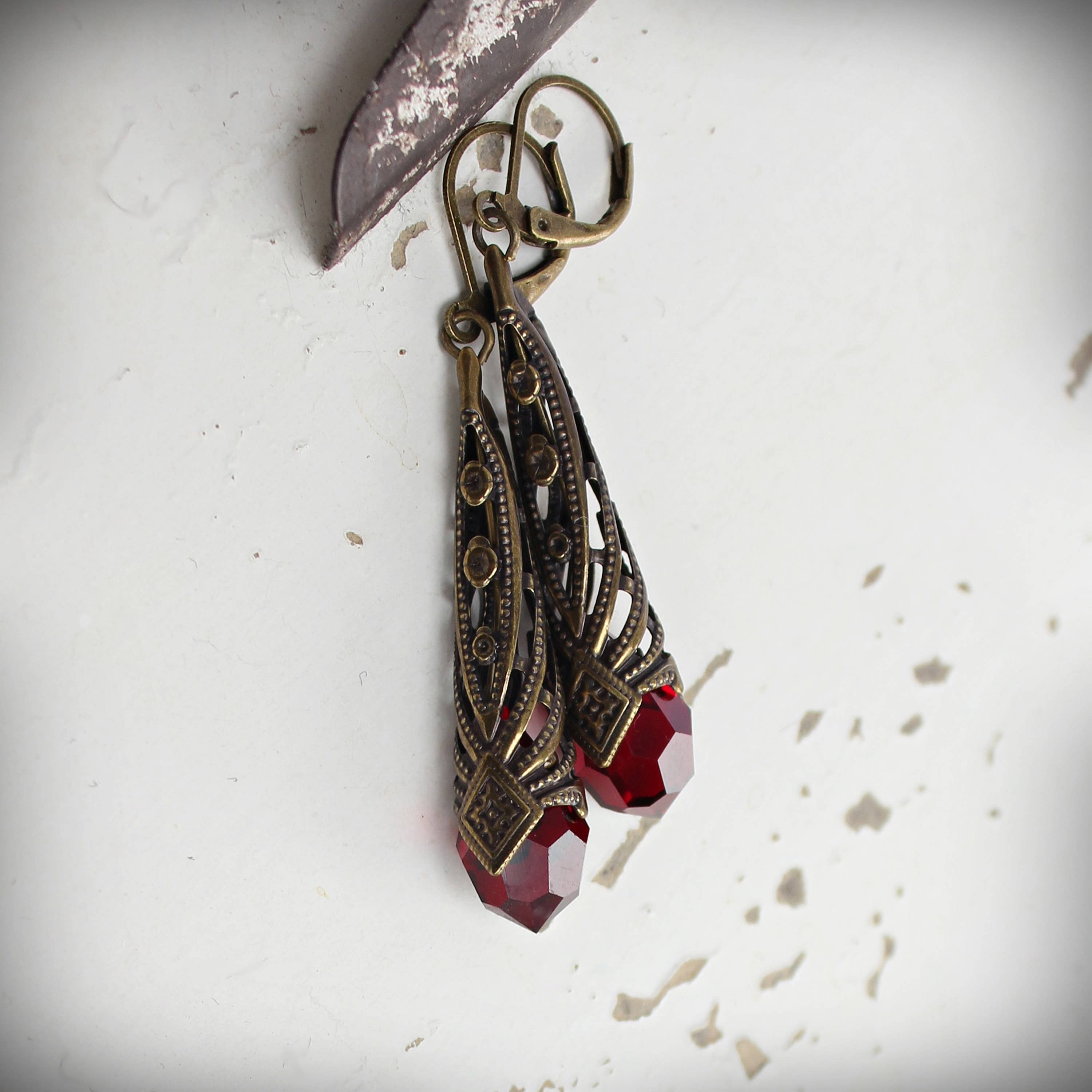 Garnet-red faceted crystal drop earrings in geometric brass setting – Circa 1890
