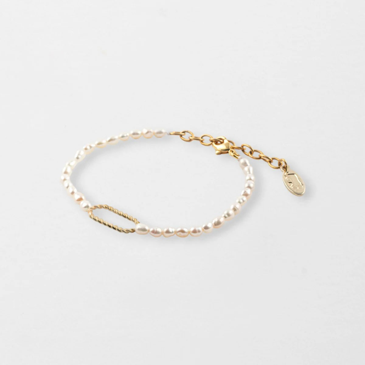 Gold and pearls bracelet on a light gray background