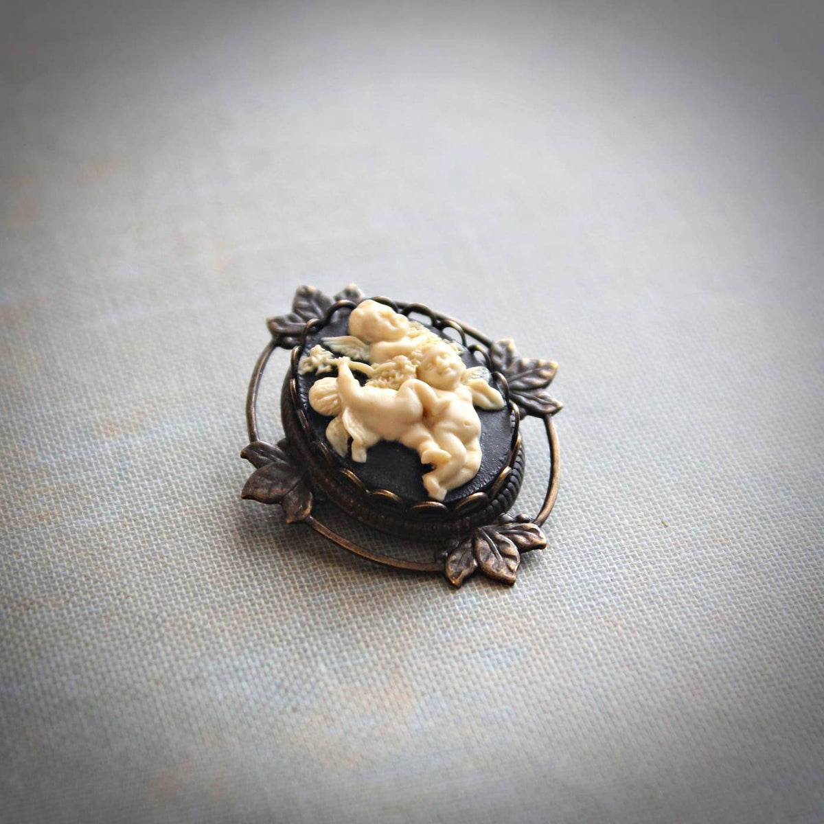 Black and ivory cherub cameo brooch pendant in antique-gold brass – Circa 1890