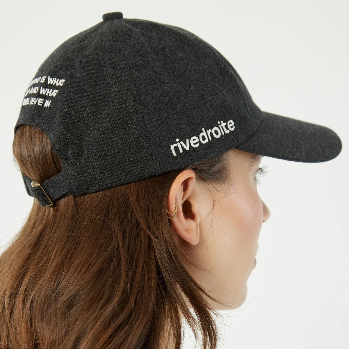 Person wearing a black cap with 'rivedroite' branding on a white background