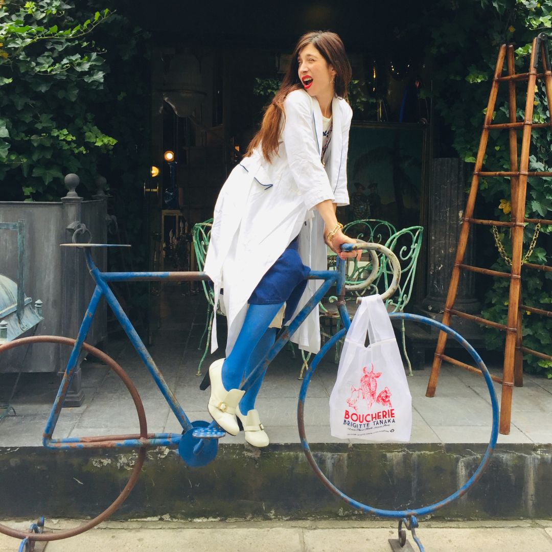 Woman on a bicycle with the red Boucherie organza bag – Brigitte Tanaka