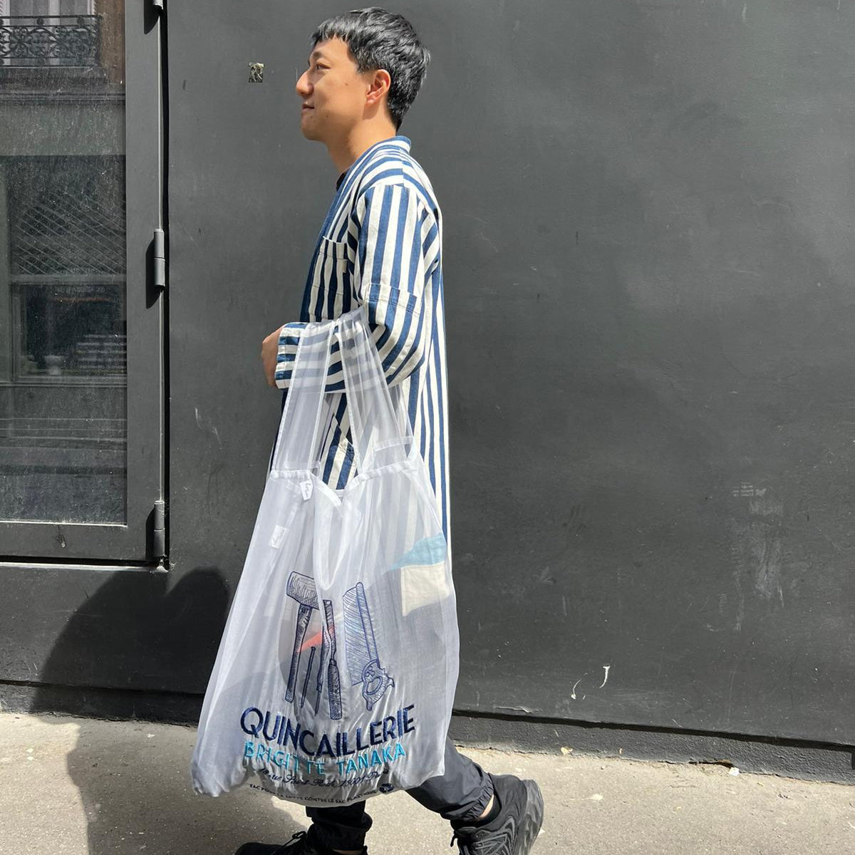 Man walking with the large Quincaillerie organza bag on his shoulder – Brigitte Tanaka