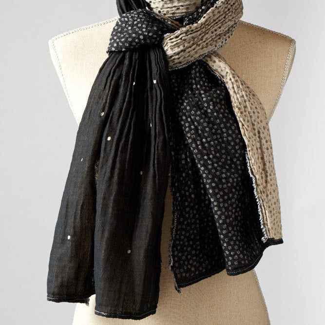 A beige and patterned scarf displayed on a mannequin.