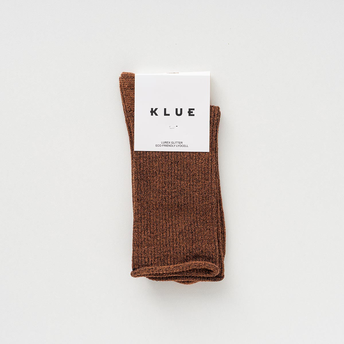 Folded pair of camel brown socks with a copper shimmer in a KLUE paper band – KLUE