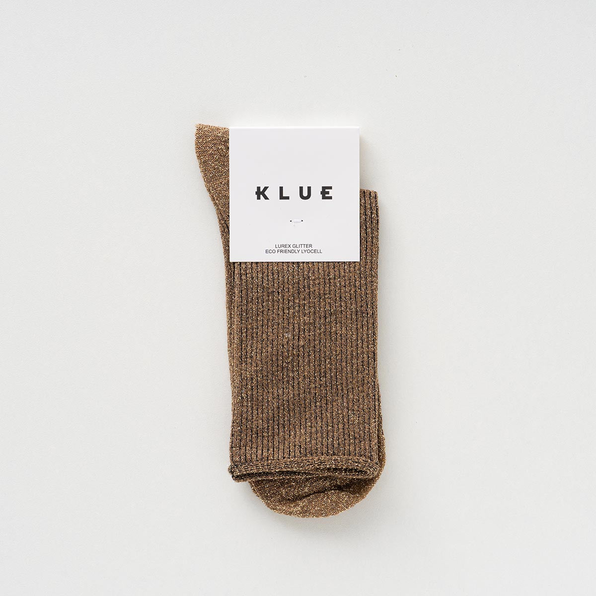 Folded pair of caramel socks with a golden glitter in a KLUE paper band – KLUE
