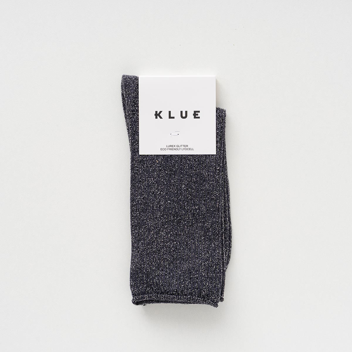 Folded pair of charcoal grey socks with a silver lurex shimmer in a KLUE paper band – KLUE