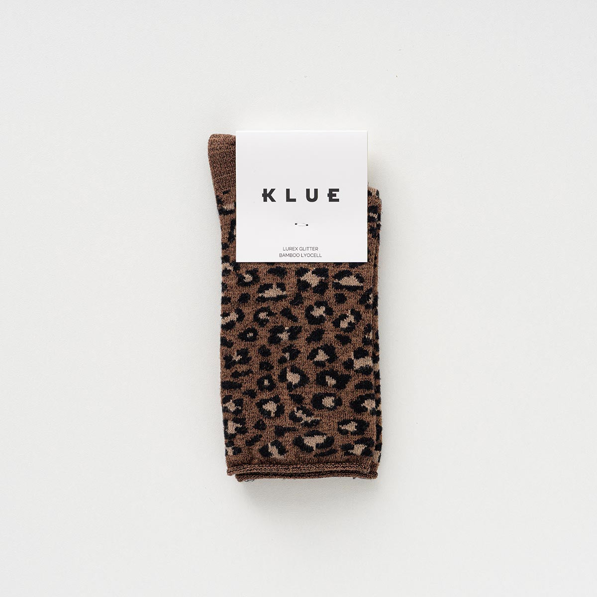 Folded pair of brown and beige leopard-print socks with glitter in a KLUE paper band – KLUE
