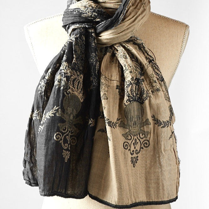A beige and patterned scarf displayed on a mannequin.