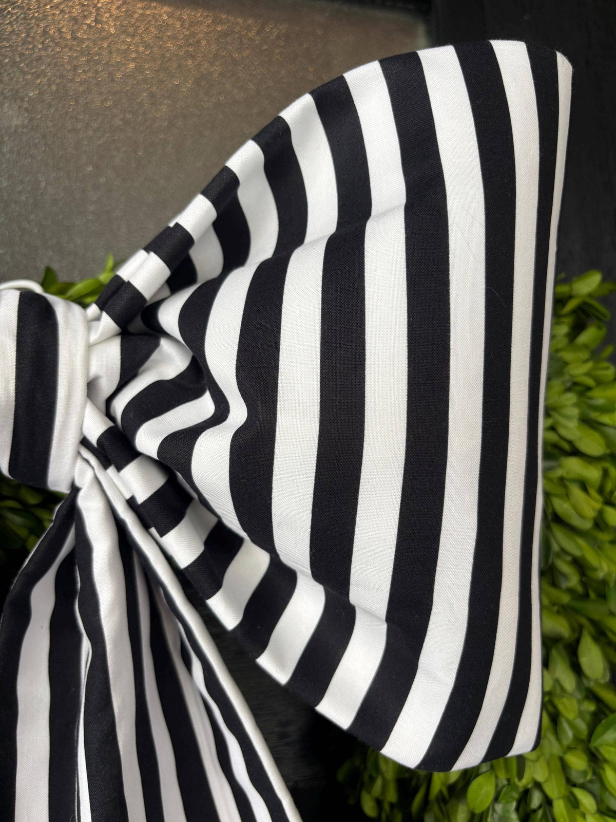 Close-up of the full sculpted loop of a bold black and white striped cotton bow – La Maison Reverie