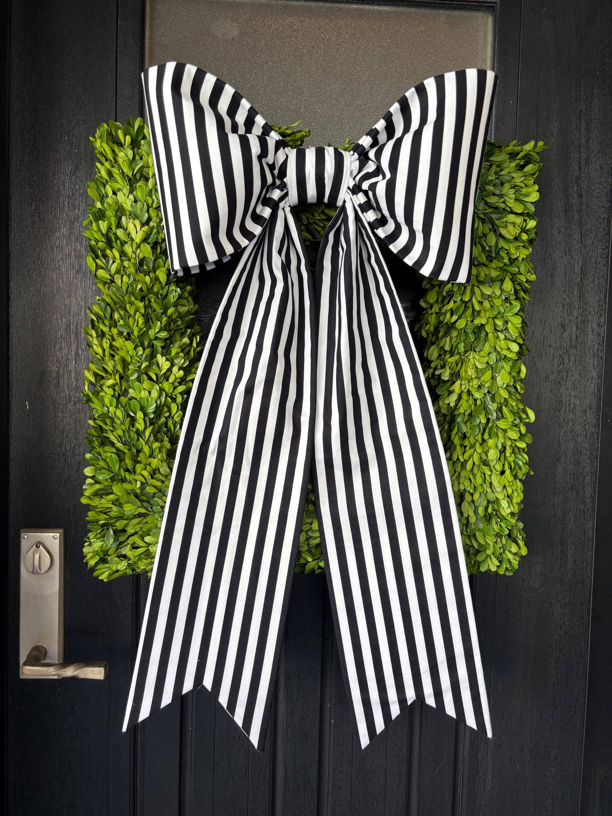 Striped cotton door bow with long notched tails over a green boxwood wreath – La Maison Reverie