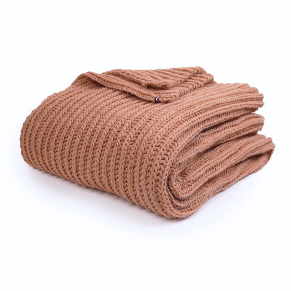 Folded brown blanket on a white background