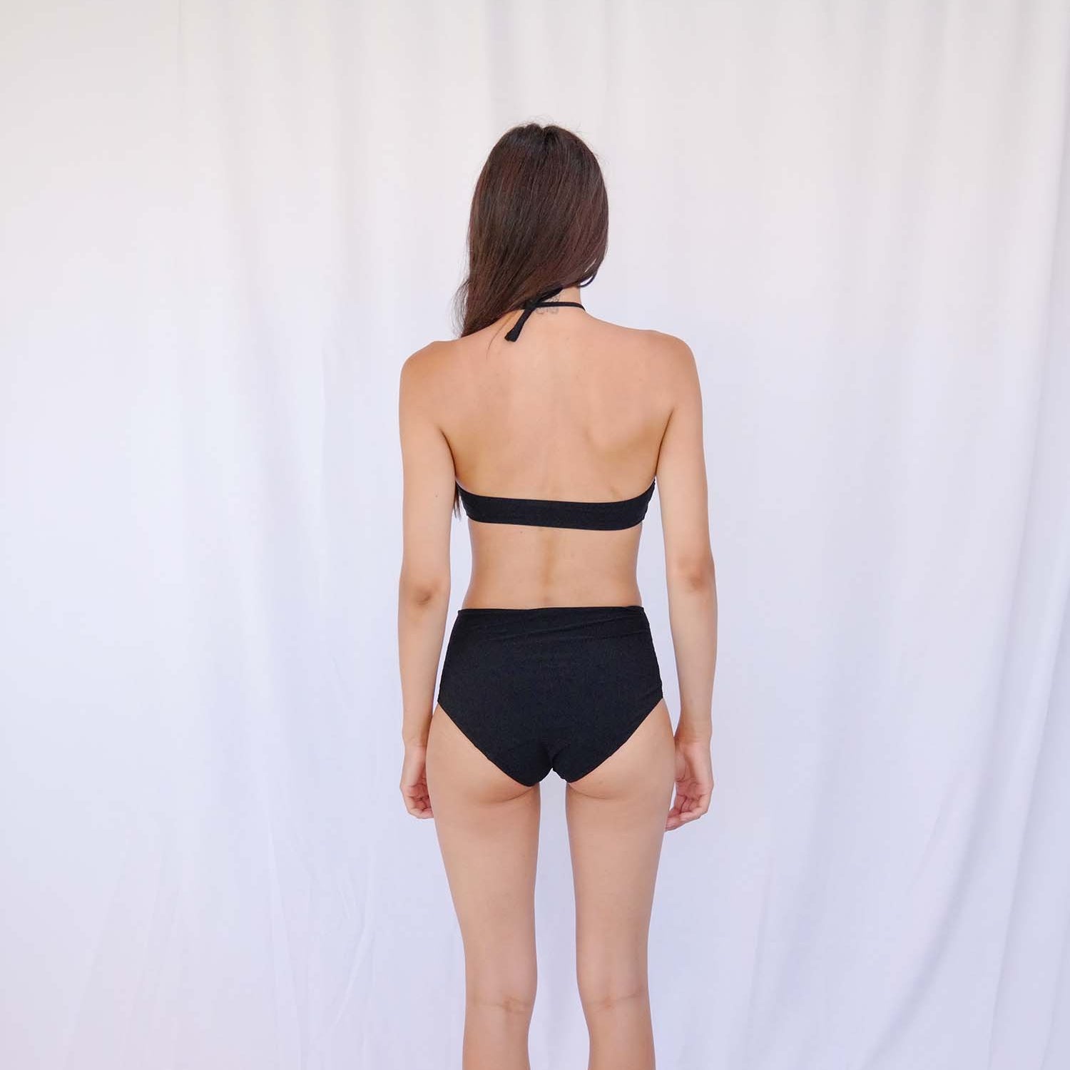 Seaside shot of the black high-waist bikini with its elongating high-rise line – Blanche Edit