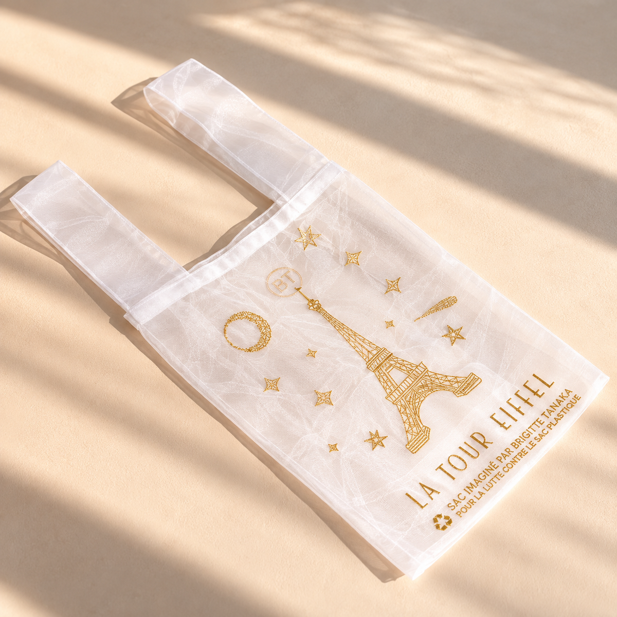 White Eiffel Tower organza bag lying flat in warm sunlight – Brigitte Tanaka