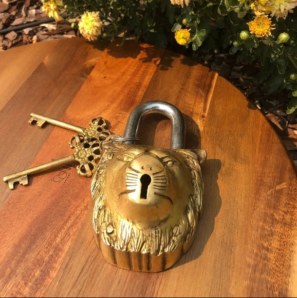 Decorative padlock and key on a wooden surface with flowers in the background