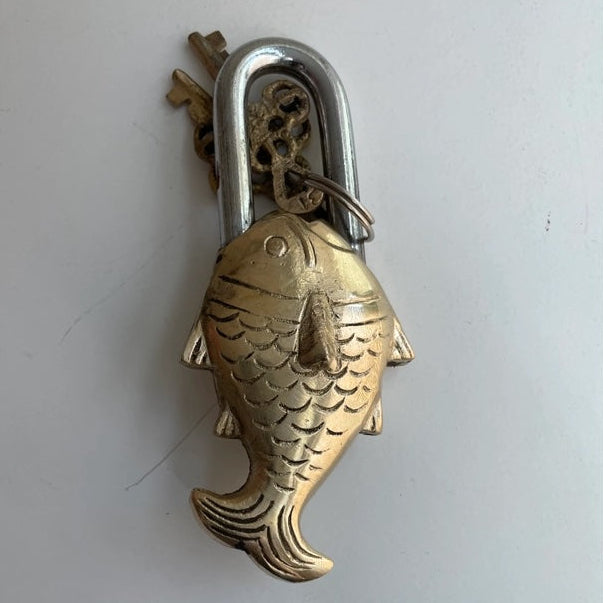 Brass fish-shaped padlock on a white background