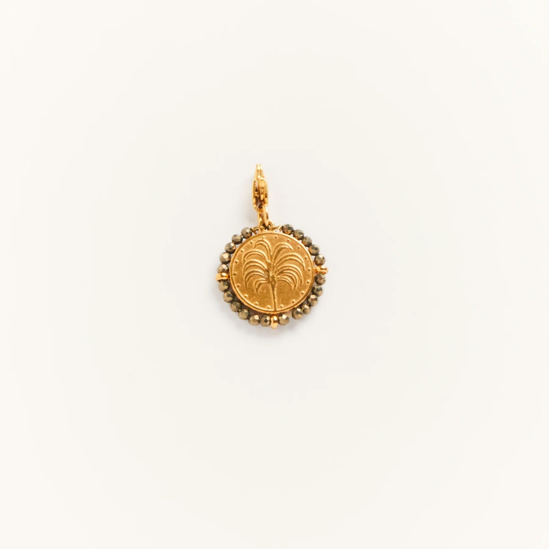 Gold pendant with decorative design on a white background