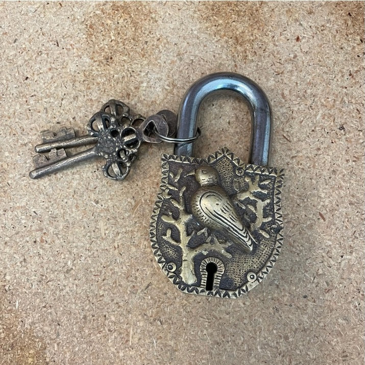 Decorative padlock with intricate design on a textured surface