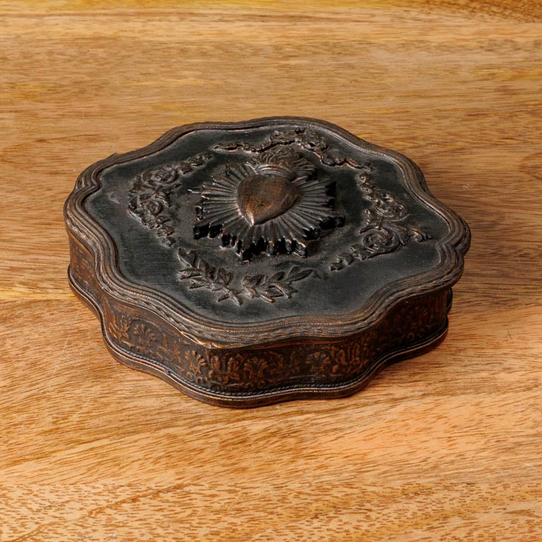 Decorative wood box with intricate designs on a wooden surface