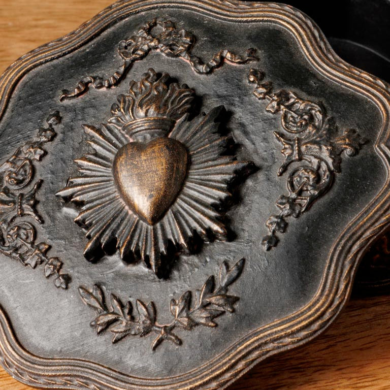 Decorative wood box with a heart emblem on a wooden surface