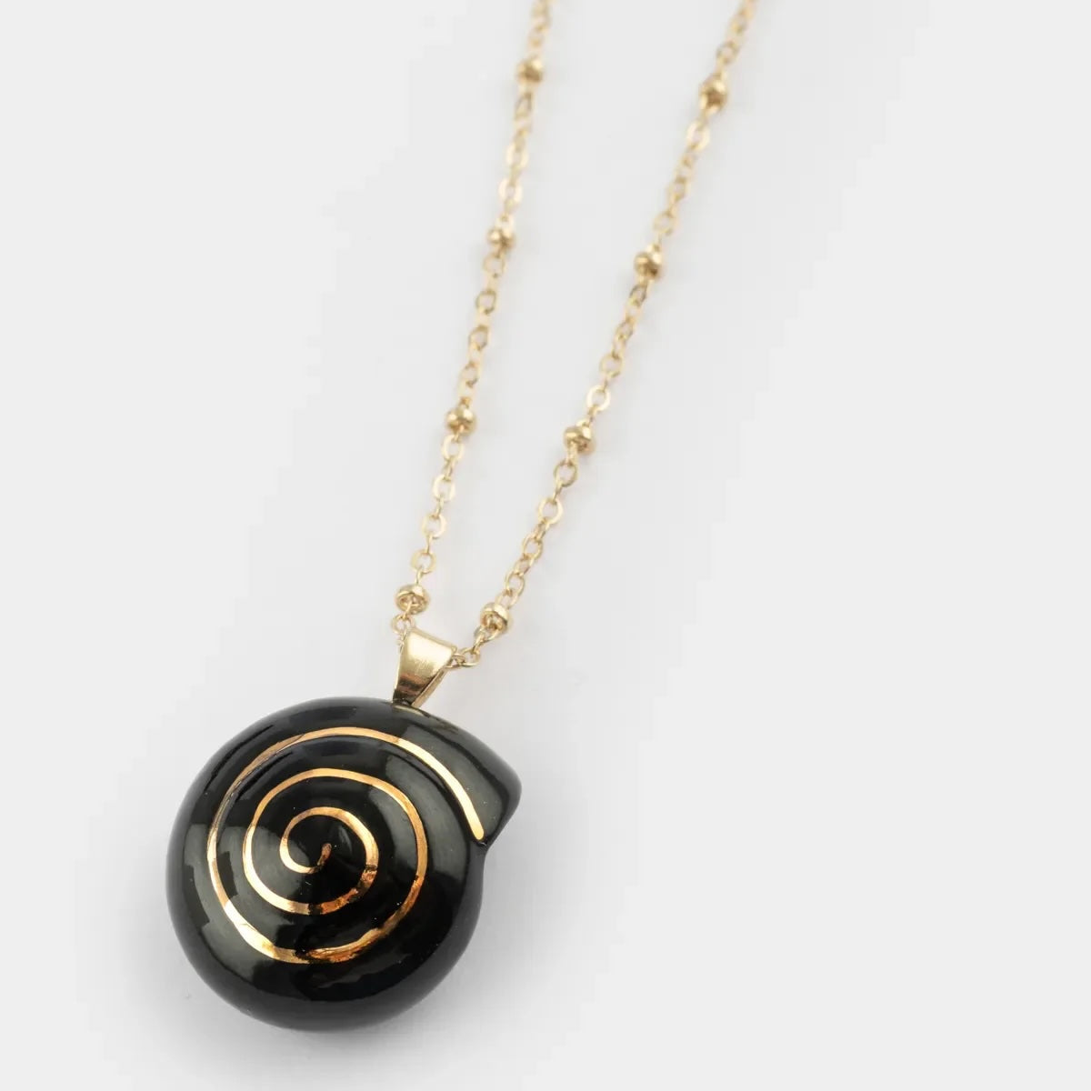 Necklace with a black spiral pendant on a white background