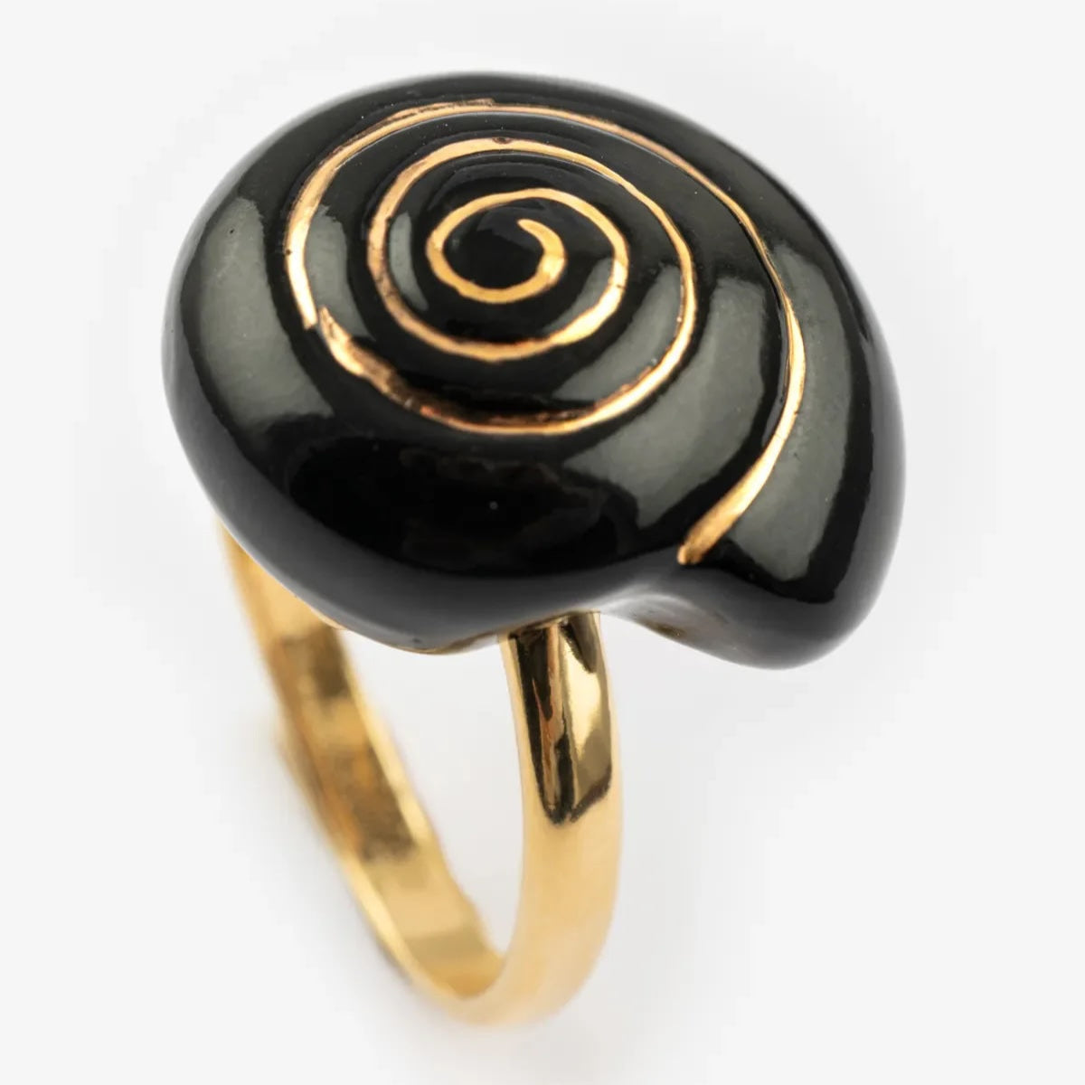 Ring with black spiral design on a gold band against a white background