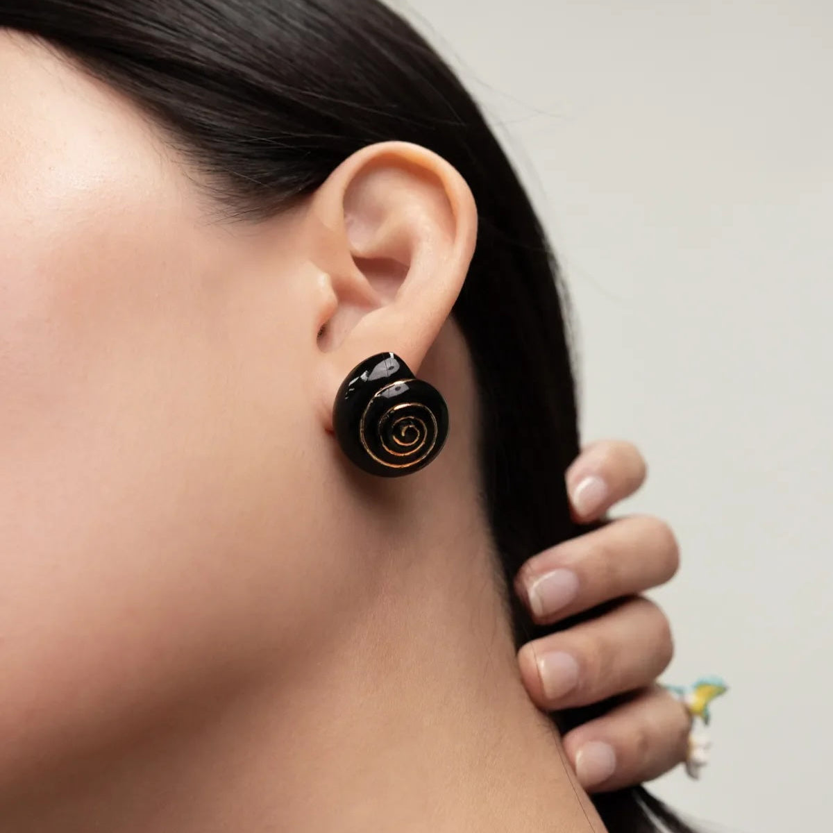 Close-up of a woman wearing a black rose-shaped earring.