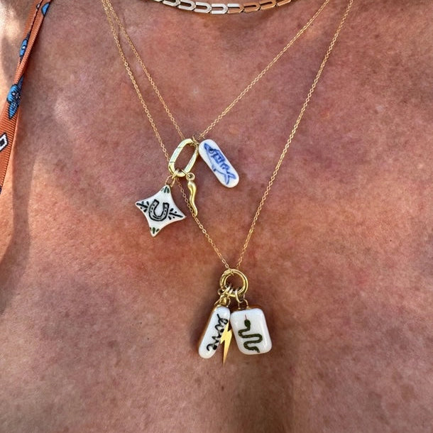 Necklace with star and square charm on a person's neck