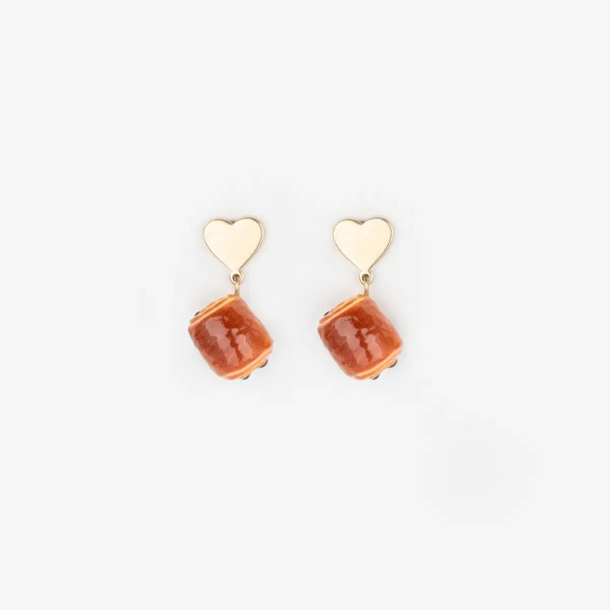 Heart-shaped earrings with chocolatine shaped porcelaine on a white background