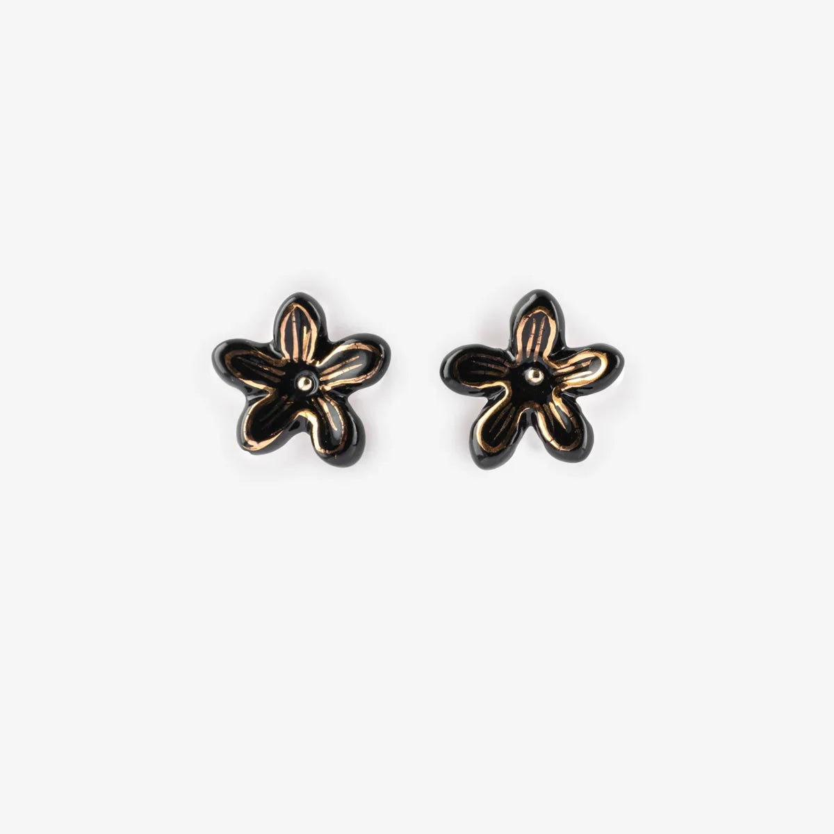 A pair of small flower-shaped stud earrings with black petals and gold-toned outlines, shown on a plain light gray background.