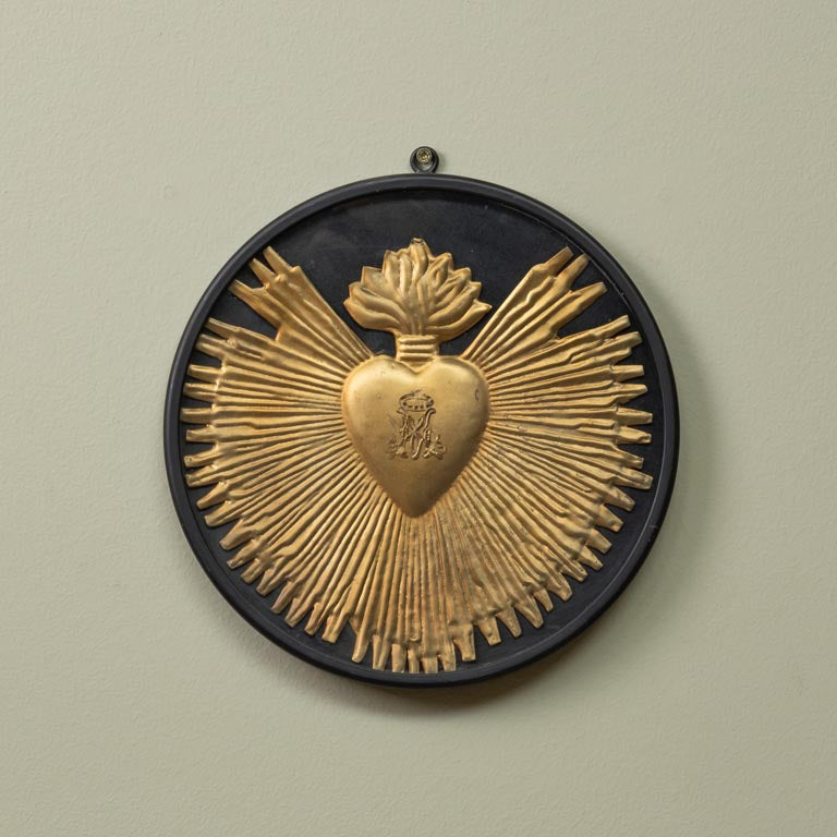 Decorative wall piece with gold heart design on a beige background