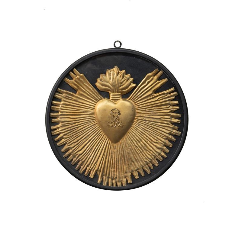 Decorative wall art with gold heart and wings design on a black background